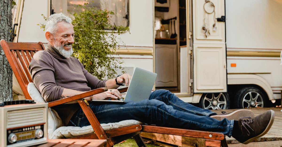 Happy gentleman relaxing by a caravan