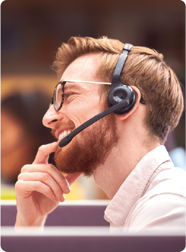 Happy man working in a call centre with a headset on.